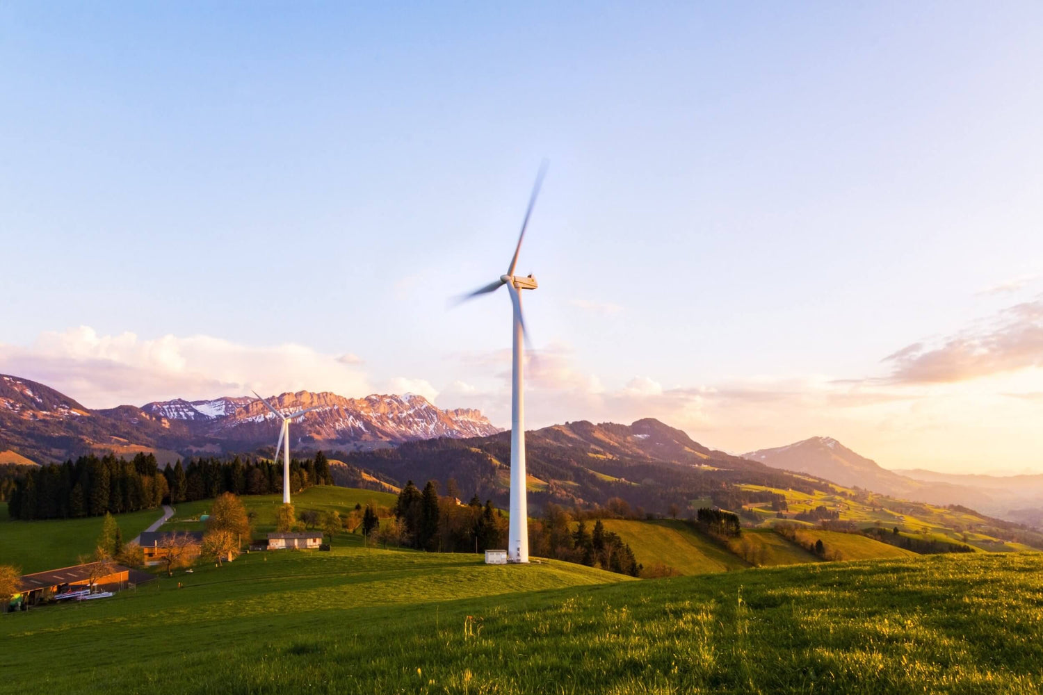 Windmills in open field with mountains in the backdrop